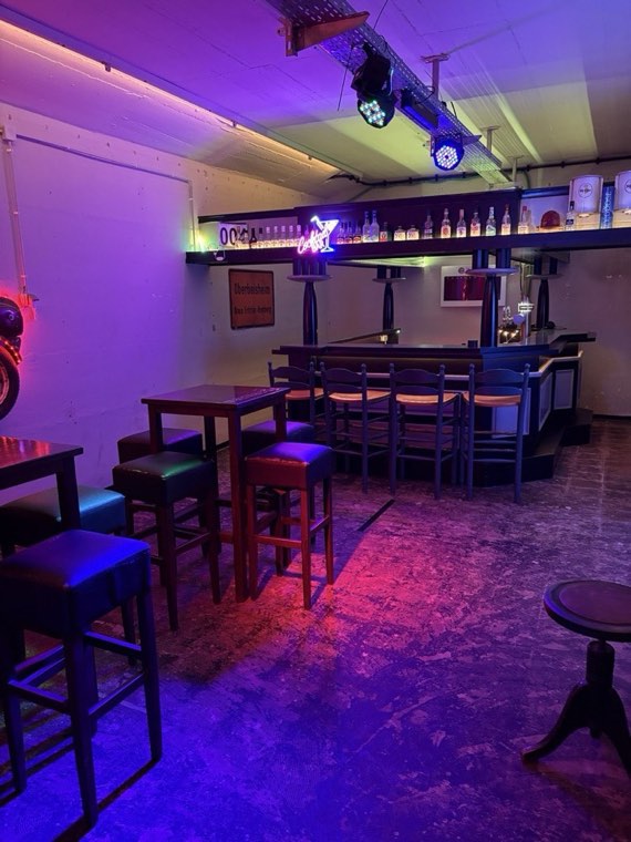 Barraum mit Stehtischen und Partylicht