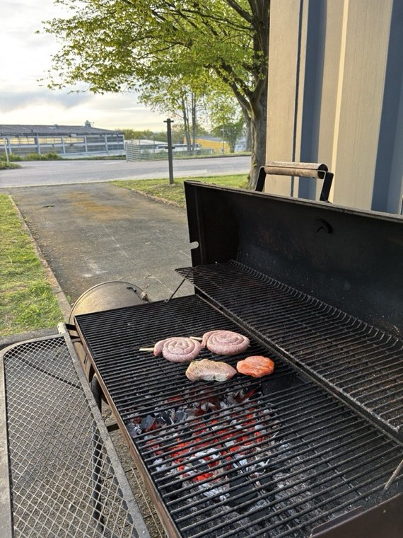 Würstchen und Steaks auf dem Holzkohlegrill vor dem Bunker